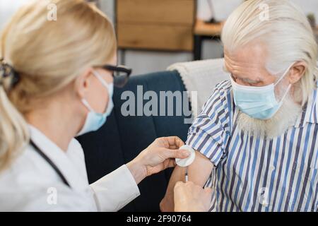 Vaccinazione, iniezione di insulina. Medico professionale di alto livello che fa l'iniezione di insulina all'anziano diabetico sopportato l'uomo durante la sua visita a casa. Foto Stock