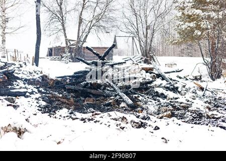 Rovine di casa bruciata in caso di incendio conflagrazione su fumo neve sfondo paesaggio invernale Foto Stock