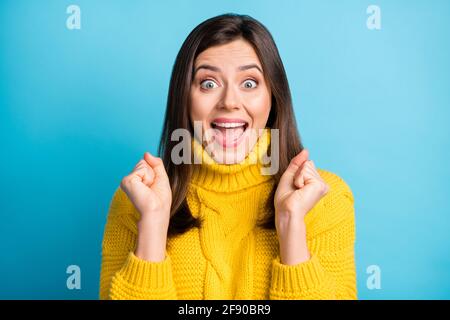 Primo piano ritratto di bella allegra fortunata ragazza che ha divertimento tenendo i pugni sono isolati su uno sfondo di colore blu brillante Foto Stock