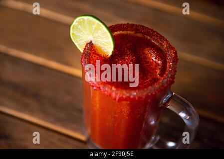 Birra Michelada con succo di pomodoro. Clamato con birra su tavola di legno. Foto Stock