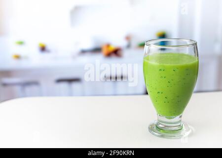 succo verde molto sano su tavolo bianco in cucina Foto Stock