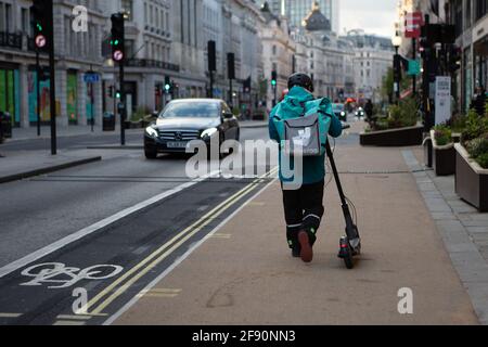 Londra, Regno Unito. 15 Aprile 2021. Il pilota del deliveroo ha visto consegnare cibo da asporto a Regent Street, Londra. (Foto di Pietro Recchia/SOPA Images/Sipa USA) Credit: Sipa USA/Alamy Live News Foto Stock
