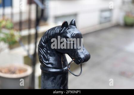 Philadelphia, PA - Marzo 26 2021: Metallo nero testa di cavallo attacco post. Pezzo storico di fronte a una casa sfocata a Filadelfia Foto Stock