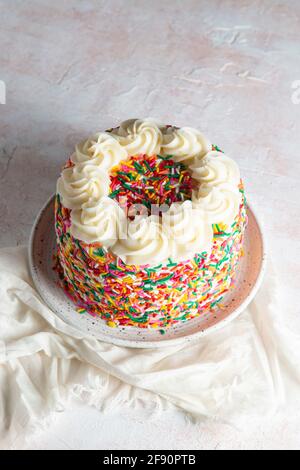 Cospargere la torta con la crema alla vaniglia Foto Stock