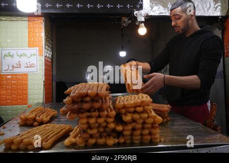 Algeri. 15 Aprile 2021. Un uomo algerino prepara i dessert in un mercato durante il mese santo islamico del Ramadan ad Algeri, Algeria, il 15 aprile 2021. Credit: Xinhua/Alamy Live News Foto Stock