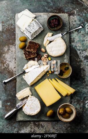 Piatto di formaggi con diversi tipi di assortimento di snack al formaggio tavola di servizio dell'ardesia Foto Stock
