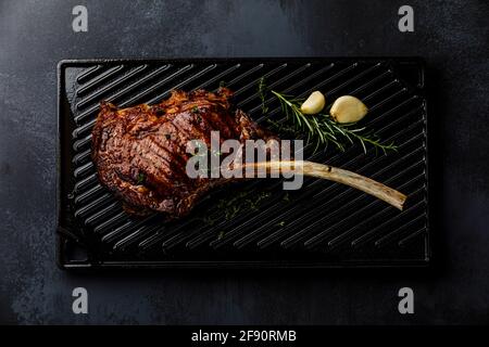 Barbecue Tomahawk Steak alla griglia su Cast Iron Grill superficie di fondo Foto Stock