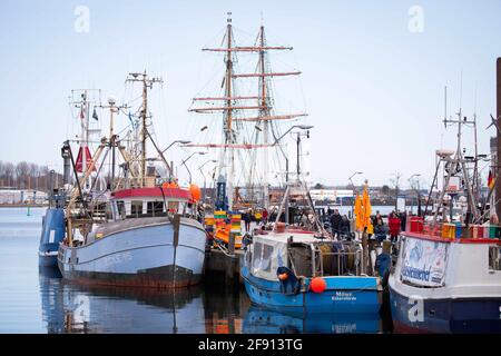 14 aprile 2021, Schleswig-Holstein, Eckernförde: Pochi passanti a piedi dietro barche da pesca e navi storiche alla punta del porto. Con l'aumento dei dati sulle infezioni, Schleswig-Holstein sta adottando misure caute per aprire il turismo, la cultura e lo sport nella crisi di Corona. (Al dpa: 'Il nuovo turismo inizia nel nord con un regime rigoroso e ritardi') Foto: Christian Charisius/dpa Foto Stock