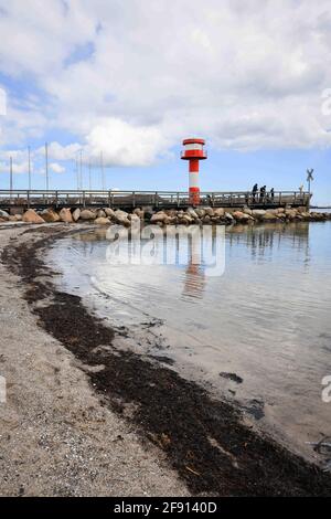 14 aprile 2021, Schleswig-Holstein, Eckernförde: Solo poche persone sono sul molo nel porto al faro alla punta del porto. Con l'aumento dei dati sulle infezioni, Schleswig-Holstein sta adottando misure caute per aprire il turismo, la cultura e lo sport nella crisi di Corona. (Al dpa: 'Il nuovo turismo inizia nel nord con un regime rigoroso e ritardi') Foto: Christian Charisius/dpa Foto Stock