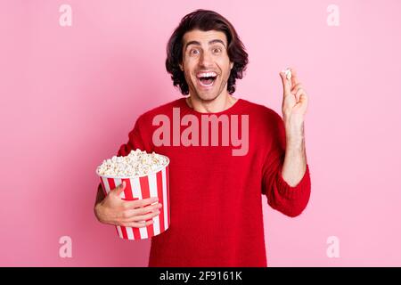 Ritratto fotografico di allegra bruna maschile felice guardando la tv mangiare popcorn isolato su sfondo di colore rosa pastello Foto Stock