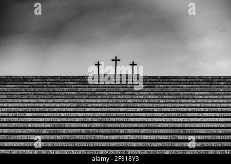 Vista in scala di grigi del Redipuglia War Memorial con tre croci sullo sfondo Foto Stock