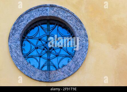 Finestra vintage rotonda su un muro arancione Foto Stock