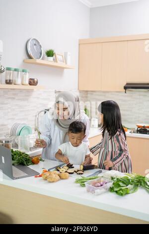 bella donna asiatica con figlia e figlio cena di cucina durante ramadan Foto Stock