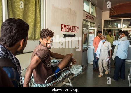 Una giovane vittima di un incidente con uno spirito piuttosto buono attende al di fuori del reparto di emergenza di un ospedale rurale a Rajasthan, India Foto Stock