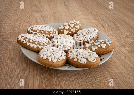 Biscotti tradizionali ungheresi di pan di zenzero (ungherese: mézeskalács) in forma di uovo e decorati con motivi pasquali su un piatto. Foto Stock