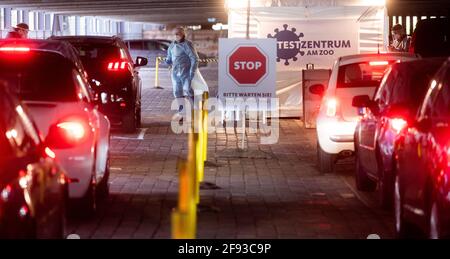 Hannover, Germania. 16 Apr 2021. Aiutanti a testare gli occupanti dell'auto al 'Test Center at the Zoo' con test rapidi per il nuovo virus corona. Il Robert Koch Institute (RKI) continua a segnalare un aumento delle nuove infezioni da corona in Germania. Credit: Julian Stratenschulte/dpa/Alamy Live News Foto Stock