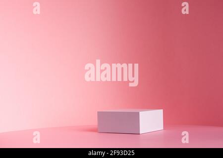Podio quadrato bianco per esposizione cosmetica e altri prodotti in luce solare su sfondo rosa pastello gradiente, spazio copia. Foto Stock