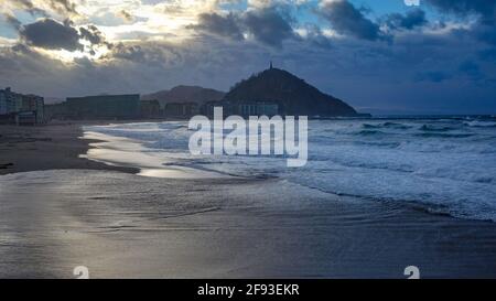 San Sebastian, Spagna - 19 febbraio 2021: Tramonto su Monte Urgull dalla spiaggia di Zurriola Foto Stock