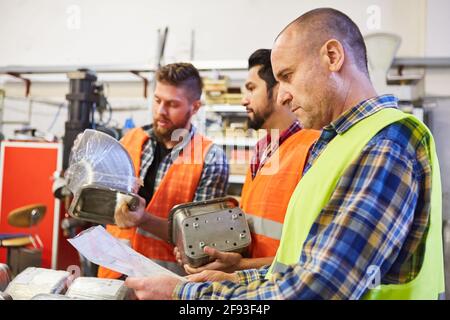 Commissionatore nel magazzino controlla con lista di controllo le merci in entrata oppure ordinare Foto Stock