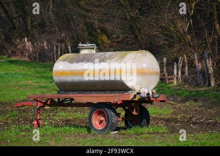 vecchi rimorchi di acqua come cavallo che beve trogolo in un campo Foto Stock