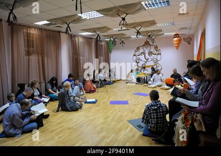 Parrocchiani di Krishna seduti su un pavimento in un tempio e ascoltando il guru. 3 aprile 2013. Kiyv, Ucraina Foto Stock