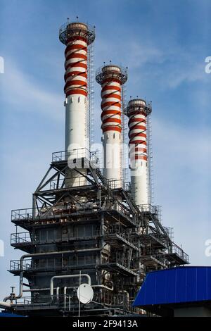 Moderna centrale a gas. Camini a strisce rosso e bianco fabbrica (pile di fumo) su sfondo blu cielo. Foto Stock