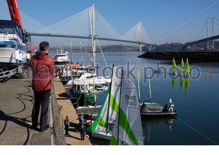 South Queensferry, Scozia, Regno Unito. 16 Apr 2021. Fresco chiaro e soleggiato a South Queensferry e Forth Estuary. Con l'allentamento delle misure di blocco di Coronavirus Covid-19 e le restrizioni di viaggio in tutta la Scozia da oggi, le persone iniziano a visitare e godersi la vita all'aperto presso i soliti luoghi di interesse turistico. Lezioni di vela a Port Edgar Marina. Credit: Craig Brown/Alamy Live News Foto Stock