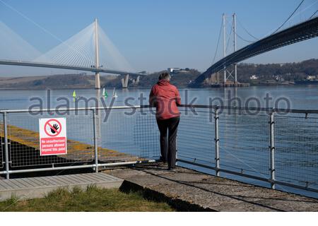 South Queensferry, Scozia, Regno Unito. 16 Apr 2021. Fresco chiaro e soleggiato a South Queensferry e Forth Estuary. Con l'allentamento delle misure di blocco di Coronavirus Covid-19 e le restrizioni di viaggio in tutta la Scozia da oggi, le persone iniziano a visitare e godersi la vita all'aperto presso i soliti luoghi di interesse turistico. Credit: Craig Brown/Alamy Live News Foto Stock