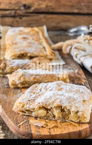 Tradizionale strudel di mele fatto in casa su un rustico tavolo in legno, verticale Foto Stock