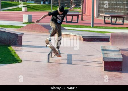 Krasnodar, Russia - Aprile 14 2021: Skateboarder fare un trucco in un parco di skate. Giovane uomo che salta in skateboard Foto Stock