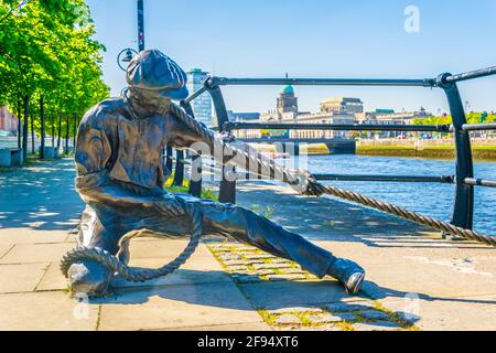 Il Linesman - scultura in bronzo del portuale sul Rive del fiume Liffey nella città di Dublino Foto Stock