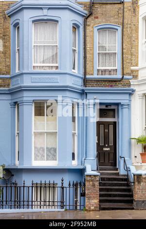Blue home exterior in una fila di appartamenti colorati nel quartiere di Notting Hill, Londra, Inghilterra, Regno Unito Foto Stock