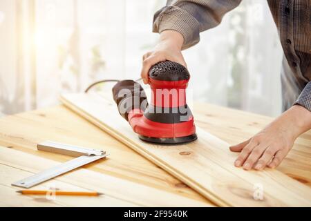 Falegname lavora con legno in officina. Una donna lavora in un laboratorio di Falegnameria. Lavori di costruzione. Foto Stock