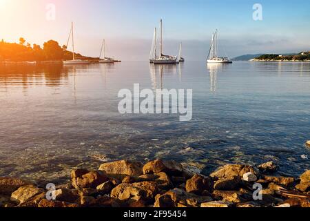 Bellissima baia con barche a vela. L'isola di Corfù. Grecia. Foto Stock