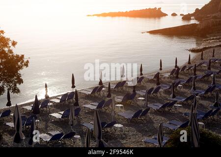 Ombrelloni e sedie a sdraio sulla spiaggia. Grecia. Corfù. Foto Stock