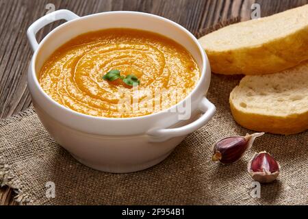 Zuppa di crema di zucca su sfondo di legno scuro. Foto Stock