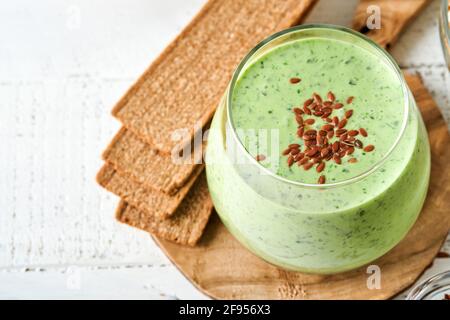 Frullato verde Detox con kale, spinaci e kiwi su un grigio chiaro ardesia, pietra o calcestruzzo fondo. Vista dall'alto con spazio per la copia. Foto Stock