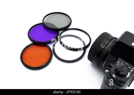 Filtri fotografici di vari colori su sfondo bianco con una fotocamera, concetto di fotografia Foto Stock