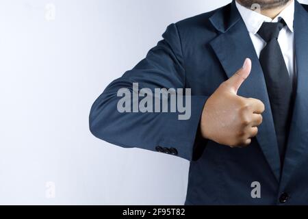 Qualcuno che gioca il ruolo di un uomo d'affari, dà un pollice in su Foto Stock