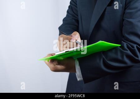 Qualcuno che gioca il ruolo di un uomo d'affari, sta agendo scrivendo o controllando Foto Stock