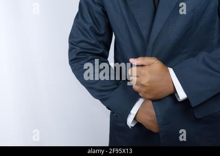 Qualcuno che gioca il ruolo di un uomo d'affari, sta fissando i suoi vestiti Foto Stock