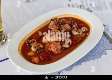 Piatto di frutti di mare in salsa di pomodoro sul tavolo Foto Stock