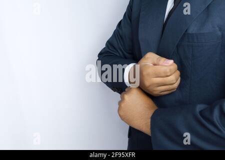 Qualcuno che gioca il ruolo di un uomo d'affari, sta fissando la sua camicia Foto Stock