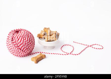 Spago rosso e bianco, treats cane marrone su sfondo bianco brillante Foto Stock