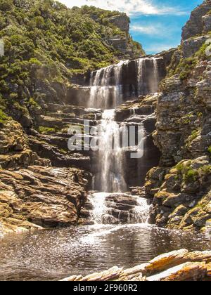 Cascata che scende lungo una scogliera il primo giorno del percorso di escursioni Otter nel Parco Nazionale Garden Route, Sud Africa Foto Stock