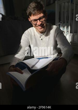 Ritratto di felice giovane uomo che studia a casa su se stesso isolamento Foto Stock