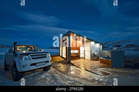 pick up camion parcheggiato al di fuori della casa illuminata di vacanza in Islanda Foto Stock