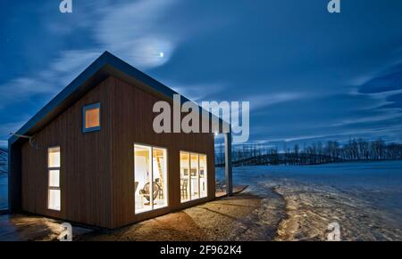 Casa vacanza illuminata in Islanda durante l'inverno Foto Stock