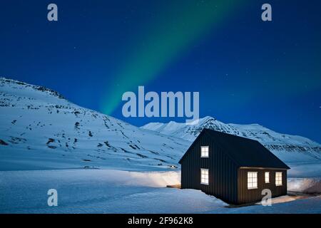 Aurora Borealis sopra cottage remoto di sci in Islanda su un notte limpida Foto Stock