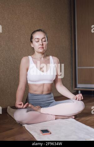 Ritratto di donna che medita a casa Foto Stock